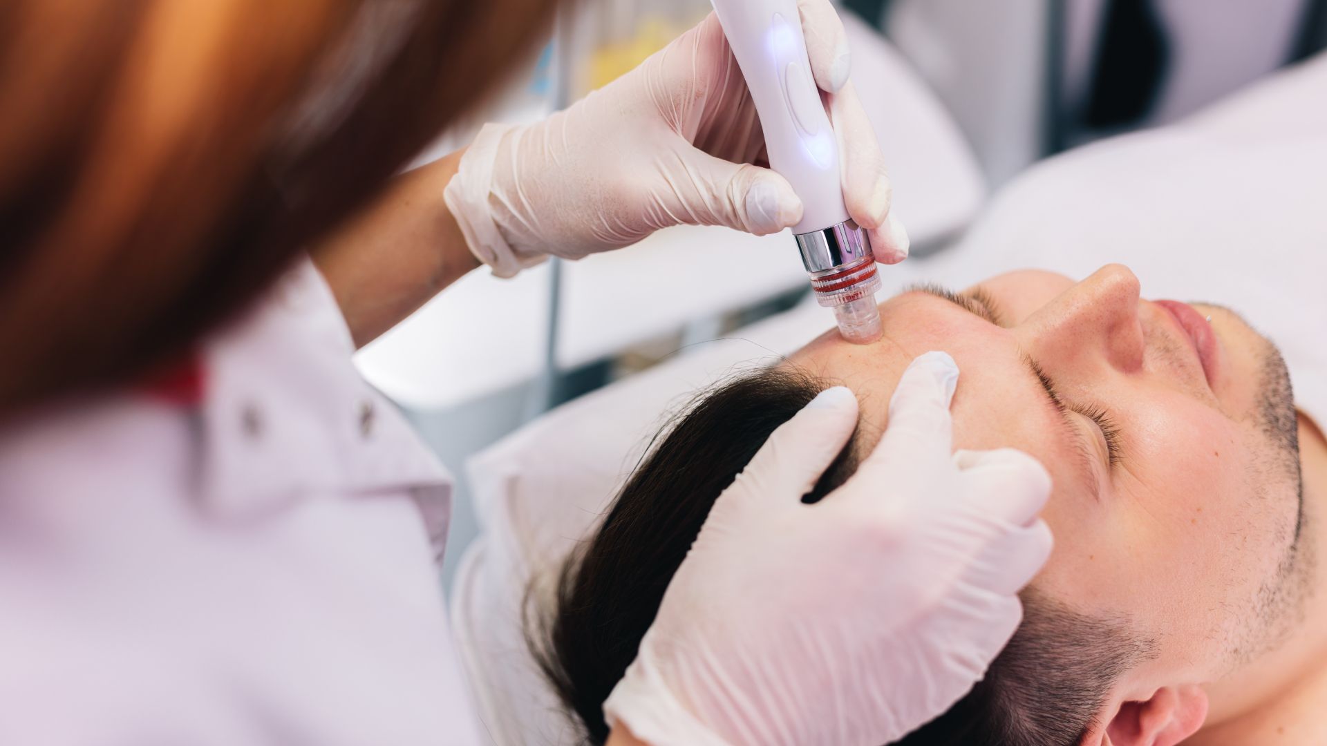 Esthetician performing a facial for men with a device in Scarborough